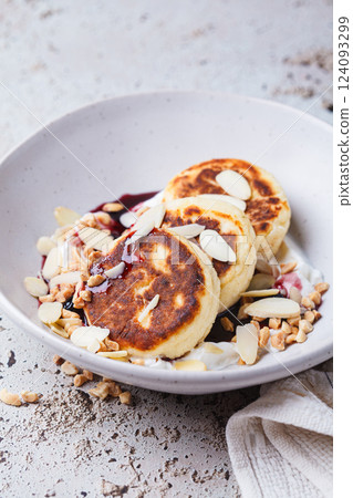 Syrniki with jam, sour cream and nuts. Syrniki with jam, sour cream and nuts. 124093299