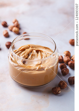 Hazelnut homemade nut butter in glass jar. Vegan snack concept. Hazelnut homemade nut butter in glass jar. Vegan snack concept. 124093307