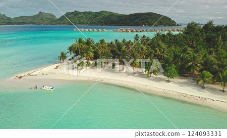 Multiple aerial views show a tropical island resort in Bora Bora with overwater bungalows, palm trees, white sand beaches, and stunning turquoise waters 124093331