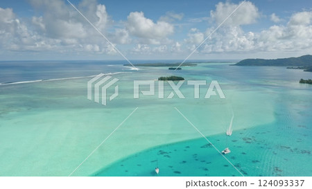 Sailboats yachts gliding turquoise water of tropical French Polynesia, surrounded by lush green islands and vibrant coral reefs under blue sky. Perfect wild nature travel background. Aerial shot 124093337