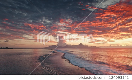 Breathtaking sunset illuminating the sky with vibrant colors over the tranquil waters of French Polynesia, with Moorea island creating a picturesque silhouette against the fiery backdrop 124093341