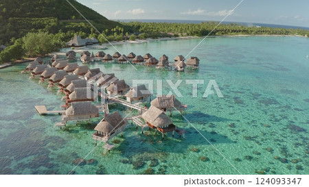 Stunning aerial view of luxurious overwater bungalows lining turquoise lagoon, Moorea island, French Polynesia. Popular tourist destination, vacation spot. Exotic travel getaway, romantic honeymoon 124093347