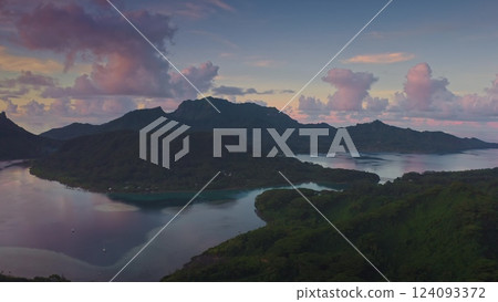 Aerial view of mount Otemanu and lagoon reflecting pink clouds at sunset, with lush tropical vegetation and calm water in Bora Bora tropical island, French Polynesia. Drone panorama 124093372