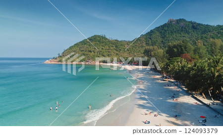 Turquoise water gently laps the shore of Bottle Beach on Koh Phangan island, Thailand, as tourists swim, sunbathe, and enjoy the tropical paradise from an aerial perspective. Travel, tourism, holiday Turquoise water gently laps the shore of Bottle Beach on Koh Phangan island, Thailand, as tourists swim, sunbathe, and enjoy the tropical paradise from an aerial perspective. Travel, tourism, holiday 124093379