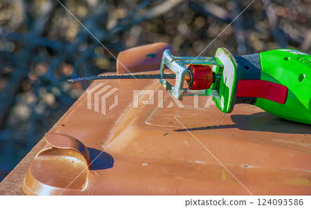 The mini electric saw for cutting small branches of trees and shrubs is ready for work. 124093586