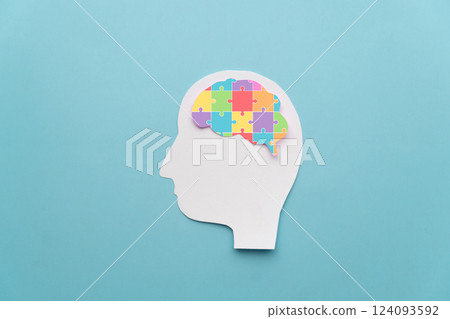 World autism awareness day concept. Human head with colorful jigsaw puzzle brain shape on blue background. Creative idea for Autism Spectrum Disorder (ASD). 124093592