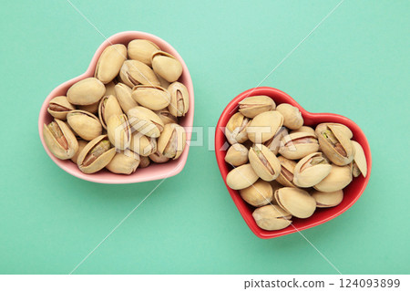 Bowls with pistachios on mint background. 124093899
