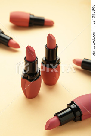 Different pastel lipsticks on beige background. 124093900