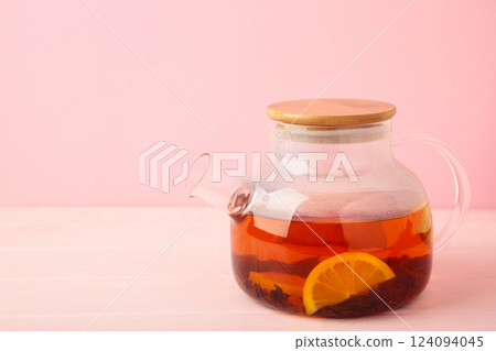 Red tea with lemon in glass teapot on pink background. Healthy drink concept. 124094045