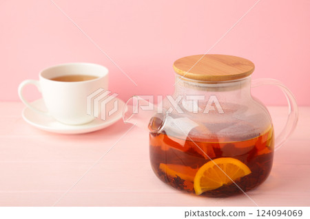 Glass teapot and cup on pink background. Glass teapot and cup on pink background. 124094069