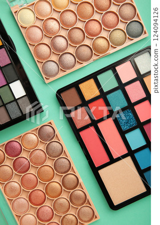 Set of eyeshadow palette on mint background. Eye shadows cosmetics product as luxury beauty brand promotion. Set of eyeshadow palette on mint background. Eye shadows cosmetics product as luxury beauty brand promotion. 124094126