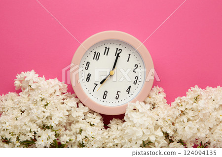 Clock with white flowers on pink background Clock with white flowers on pink background 124094135