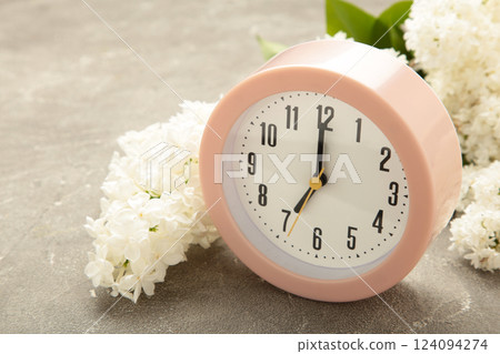 Clock with white flowers on grey background 124094274