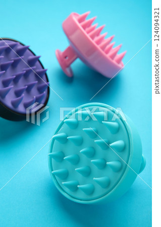 Brush for hair growth stimulating brush. Massage brush on blue background. Vertical photo 124094321