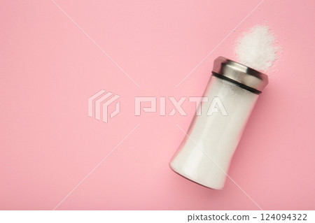 Glass salt shaker on pink background. Space for text 124094322