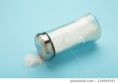 Glass salt shaker on blue background. Space for text 124094341