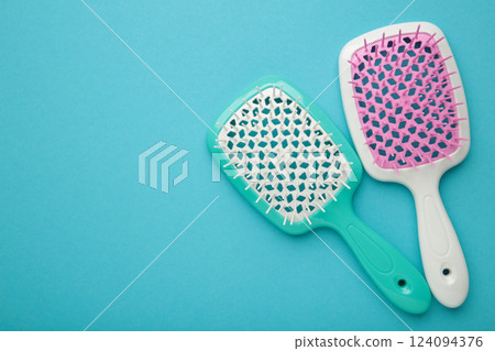 Two hairbrushes on blue background. Flat lay. Space for text 124094376