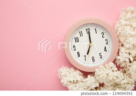 Clock alarm and lilac flowers on pink background. Environment concept. spring season. copy space. Clock alarm and lilac flowers on pink background. Environment concept. spring season. copy space. 124094391