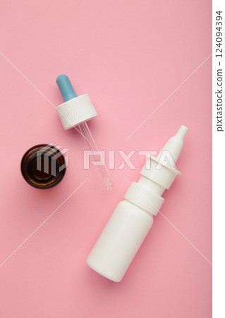 Bottles of nasal drops on pink background. Vertical photo 124094394