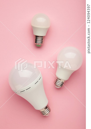 Comparison of different light bulbs on pink background. Vertical photo 124094397