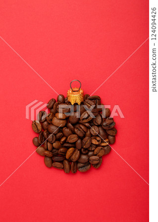 Christmas ball is made from coffee beans on red background. Holiday concept. Christmas ball is made from coffee beans on red background. Holiday concept. 124094426