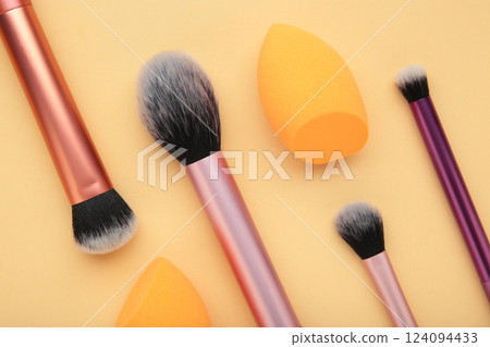 Makeup buffer brush and beauty makeup sponges on beige background. Beauty and makeup concept 124094433