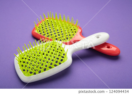 Plastic hairbrushes on violet background. 124094434