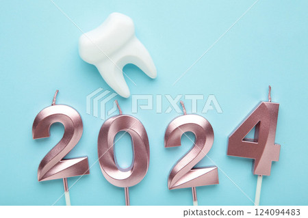 Figure 2024 and tooth with Christmas decoration on blue background. Figure 2024 and tooth with Christmas decoration on blue background. 124094483
