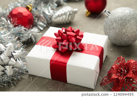 Christmas composition. Gifts, red and silver decorations on grey background. New year concept. Christmas composition. Gifts, red and silver decorations on grey background. New year concept. 124094495
