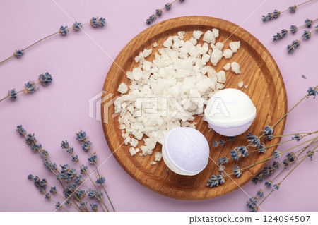Natural cosmetics. Handmade lavender bath bombs and lavender flowers on wooden board on purple background. Natural cosmetics. Handmade lavender bath bombs and lavender flowers on wooden board on purple background. 124094507