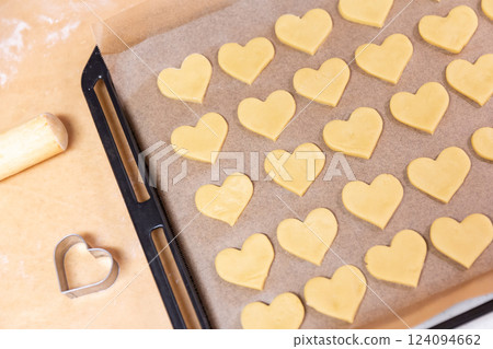 Heart-shaped cookies lined up on a baking sheet before baking Heart-shaped cookies lined up on a baking sheet before baking 124094662