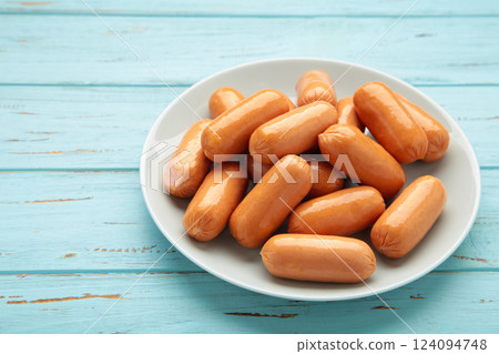 Chicken cocktail sausage on plate on blue wooden background. Space for text Chicken cocktail sausage on plate on blue wooden background. Space for text 124094748