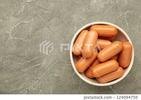 Chicken cocktail sausage on bowl on grey concrete background. Space for text Chicken cocktail sausage on bowl on grey concrete background. Space for text 124094750