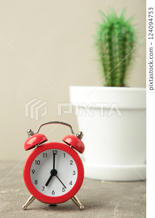 Red vintage old alarm clock and small cactus on grey background 124094753
