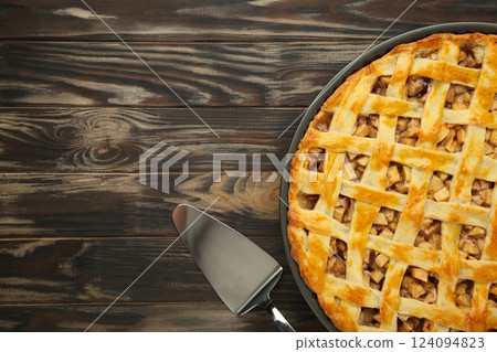 Homemade sweet american apple pie with sugar and cinnamon. Tart on brown background. 124094823