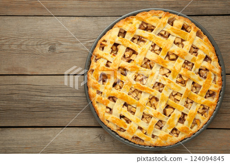 Homemade sweet american apple pie with sugar and cinnamon. Tart on grey wooden background. Homemade sweet american apple pie with sugar and cinnamon. Tart on grey wooden background. 124094845