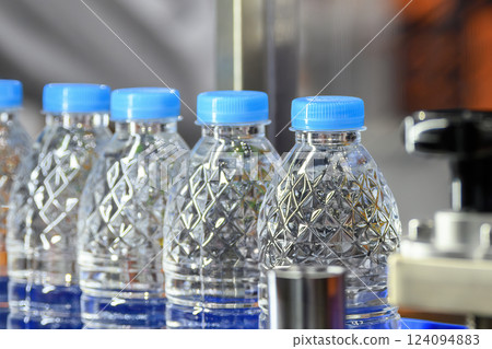 The full filled drinking water bottles on the conveyor belt. The full filled drinking water bottles on the conveyor belt. 124094883