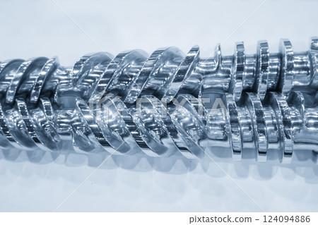 Close up scene body of the barrel screw of injection machine spare parts in the light blue scene. Close up scene body of the barrel screw of injection machine spare parts in the light blue scene. 124094886