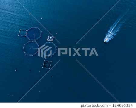 A boat heading to an aquaculture facility on the sea A boat heading to an aquaculture facility on the sea 124095384