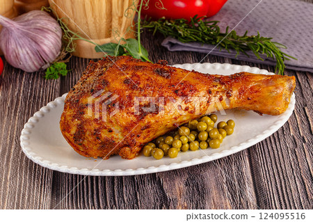 Baked turkey drumstick served green peas 124095516