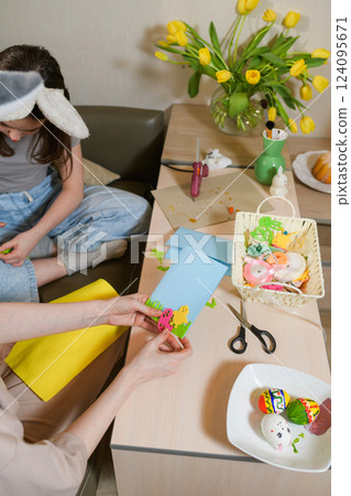 Mother and daughter creating Easter greeting cards with colorful felt cutouts. Mother and daughter creating Easter greeting cards with colorful felt cutouts. 124095671
