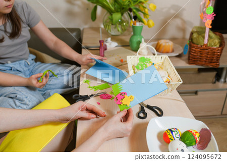 Mother and daughter creating Easter greeting cards with colorful felt cutouts. Mother and daughter creating Easter greeting cards with colorful felt cutouts. 124095672