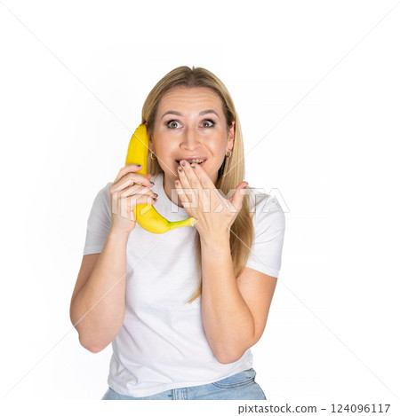Young blonde beautiful woman holding banana. Blond woman in white t-shirt hold bananas on white background 124096117