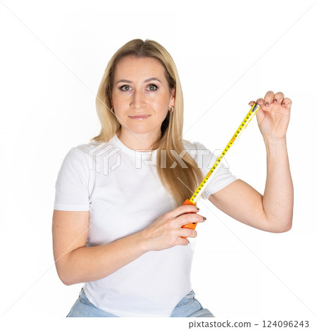 Blonde white woman holds a measuring tape. Roll Measuring Tape In Woman's Hand. building concept Blonde white woman holds a measuring tape. Roll Measuring Tape In Woman's Hand. building concept 124096243