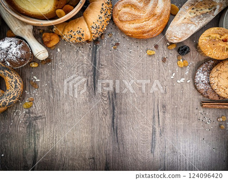 Bakery - various kinds of breadstuff. Bread rolls, baguette, bagel, sweet bun and croissant captured from above (top view, flat lay). wooden rustic background, copy space. Horizontal banner layout. Bakery - various kinds of breadstuff. Bread rolls, baguette, bagel, sweet bun and croissant captured from above (top view, flat lay). wooden rustic background, copy space. Horizontal banner layout. 124096420