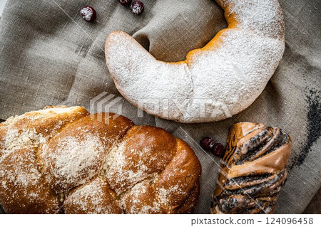 Assortment of fresh baked bread and buns on wooden table background, top view Assortment of fresh baked bread and buns on wooden table background, top view 124096458