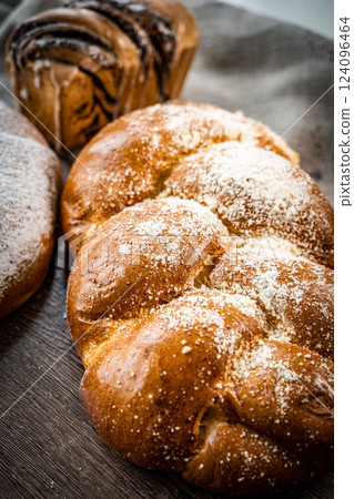 Assortment of fresh baked bread and buns on wooden table background, top view 124096464