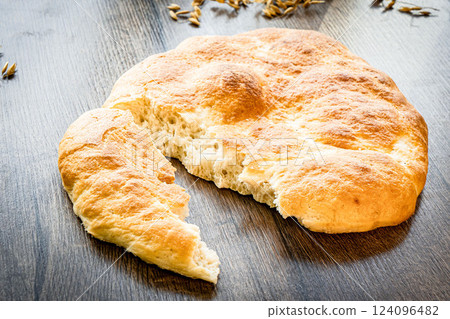 Homemade Italian Focaccia Modenese, with rosemary and olive oil on a rustic wooden background. 124096482