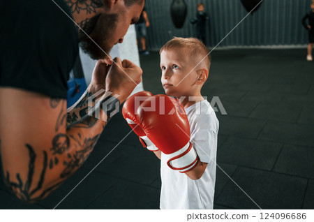 Preparing for the sparring. Coach is teaching the boy box techniques indoors 124096686