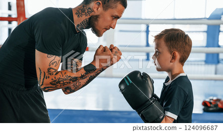 Preparing for the sparring. Coach is teaching the boy box techniques indoors 124096687